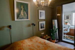 Barcelona home tour: sage green master bedroom with Hermes throw and vintage chandelier