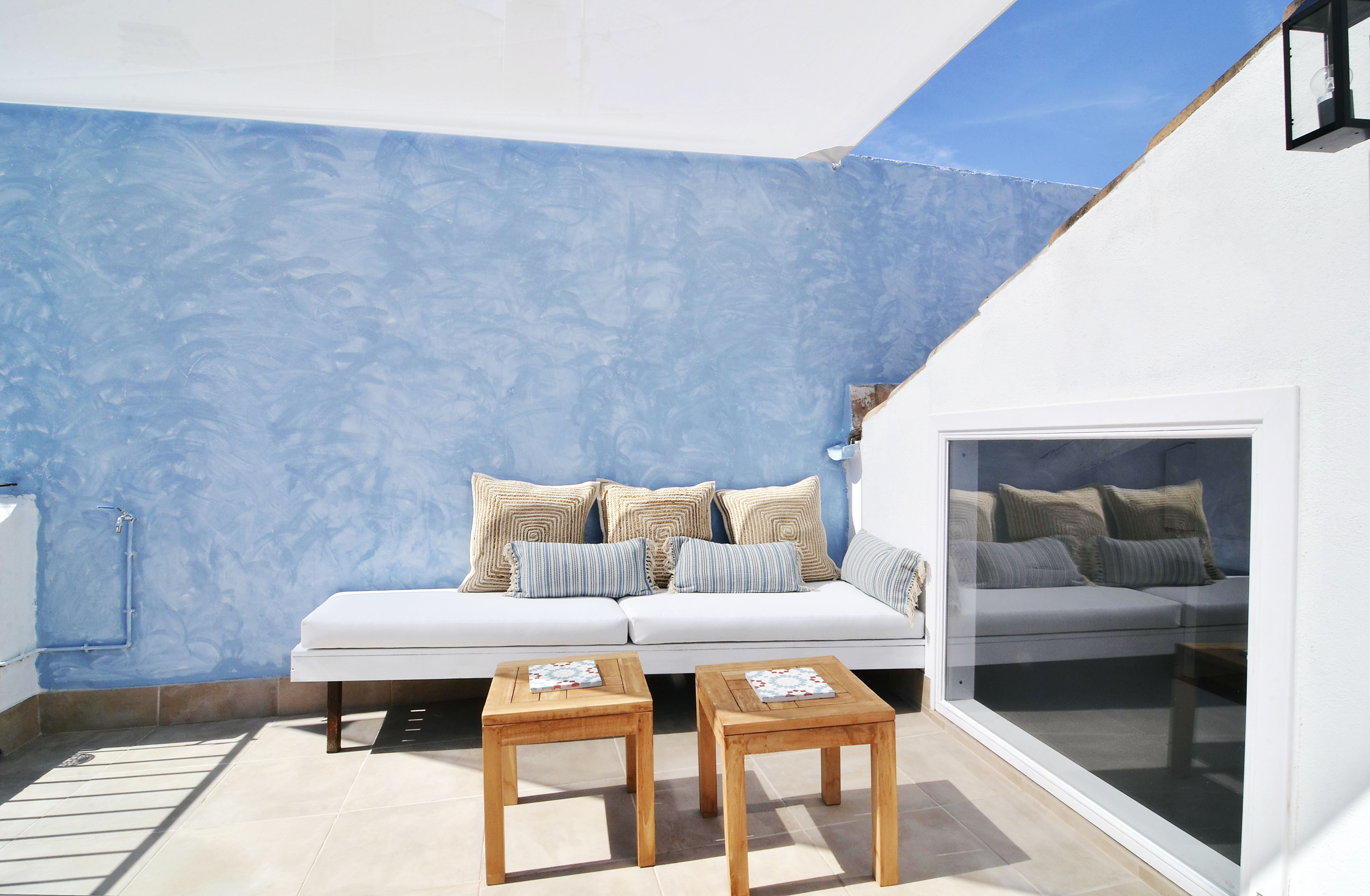 House tour: old fisherman's house in Sitges: sun-lit terrace with a blue wall